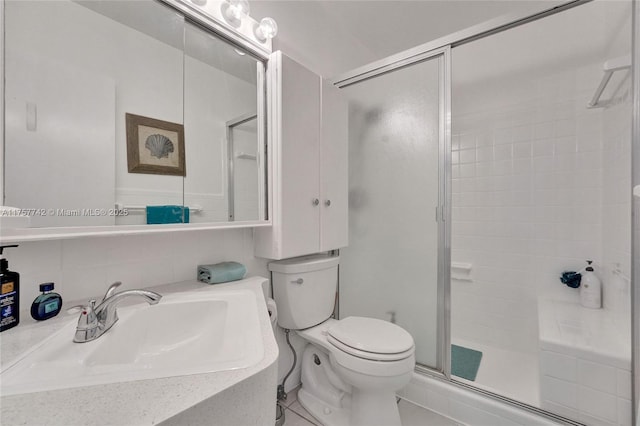 bathroom featuring toilet, a stall shower, and vanity