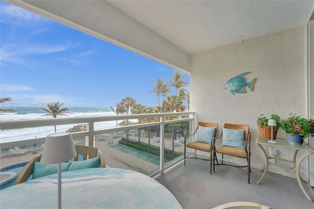 balcony featuring a water view and a view of the beach