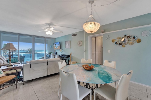 dining space with ceiling fan with notable chandelier, visible vents, and light tile patterned flooring