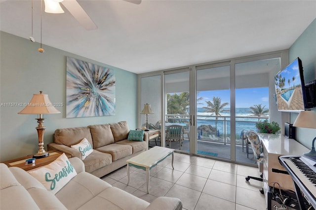 tiled living room with a wall of windows and ceiling fan