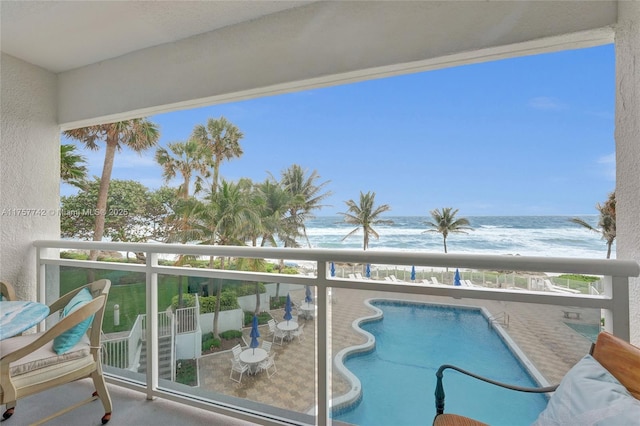 balcony featuring a water view and a view of the beach