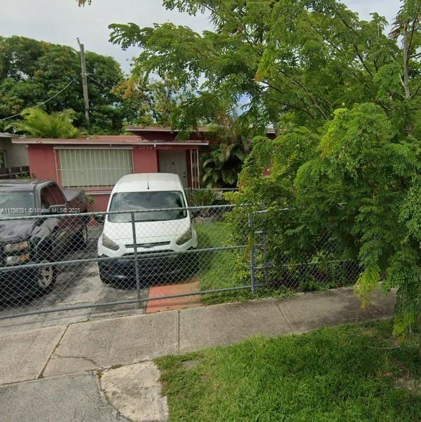 view of parking / parking lot with fence