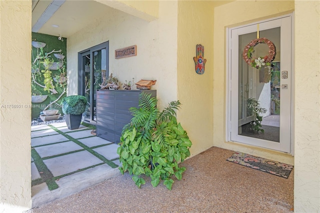 entrance to property featuring stucco siding