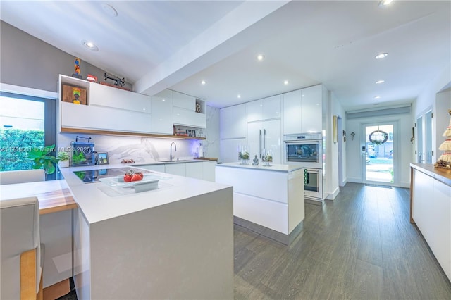 kitchen featuring a sink, modern cabinets, stainless steel double oven, and open shelves