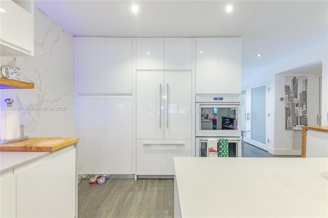 kitchen featuring light countertops, white double oven, built in fridge, white cabinetry, and modern cabinets