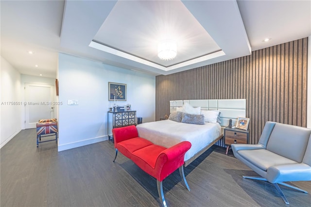 bedroom featuring a raised ceiling, recessed lighting, wood finished floors, and baseboards