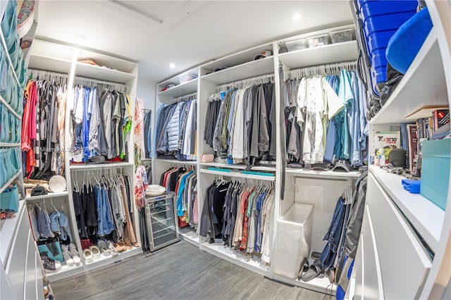 walk in closet featuring attic access and wood finished floors