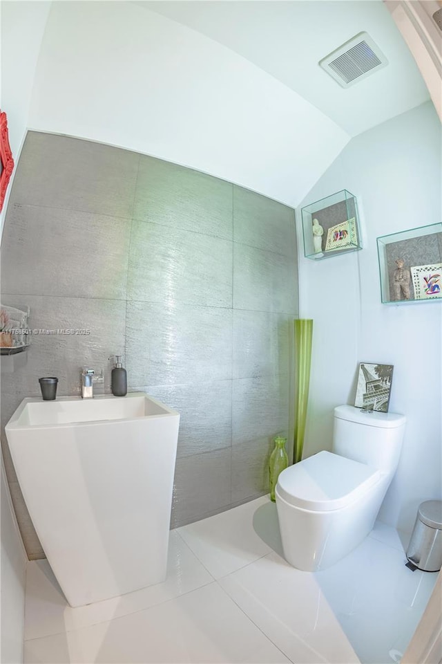 bathroom featuring tile patterned flooring, vaulted ceiling, toilet, and visible vents