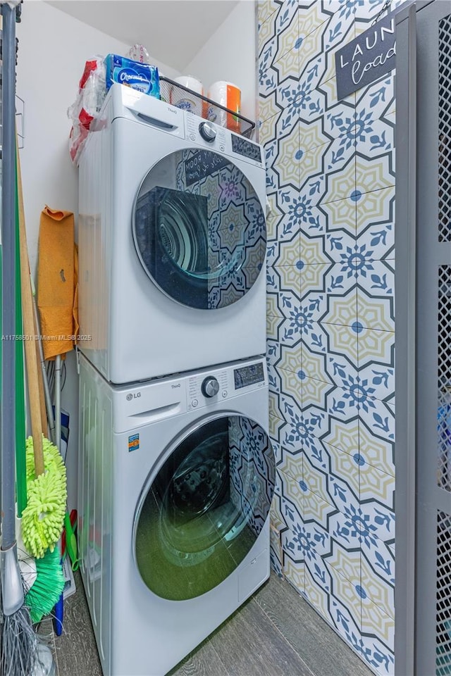 washroom featuring stacked washer / dryer and laundry area