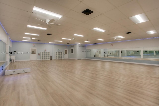 exercise room featuring visible vents, a paneled ceiling, ceiling fan, and wood finished floors