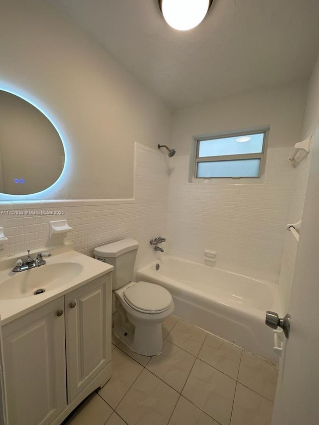 bathroom with shower / bathtub combination, toilet, vanity, tile walls, and tile patterned floors