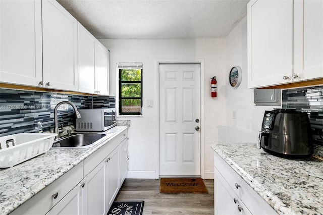 kitchen featuring wood finished floors, white cabinetry, and decorative backsplash