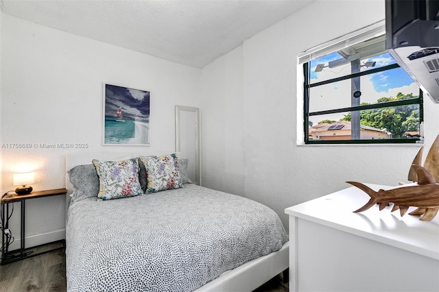 bedroom featuring baseboards and wood finished floors