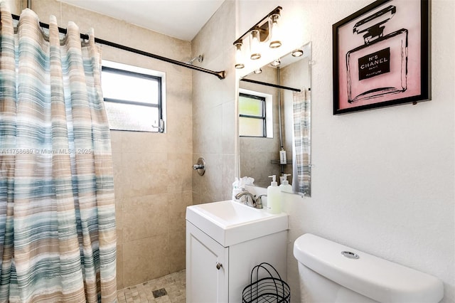 full bathroom featuring a healthy amount of sunlight, toilet, and tiled shower