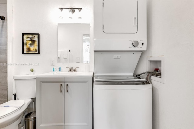 washroom featuring laundry area, stacked washing maching and dryer, and a sink