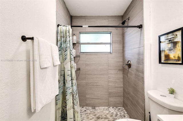 full bath featuring a shower stall and toilet