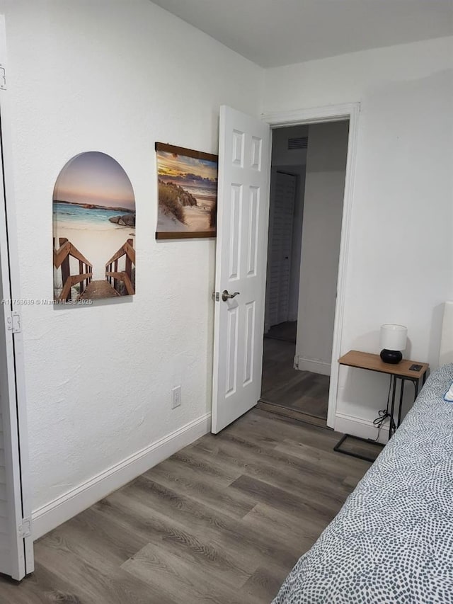 bedroom with baseboards and wood finished floors