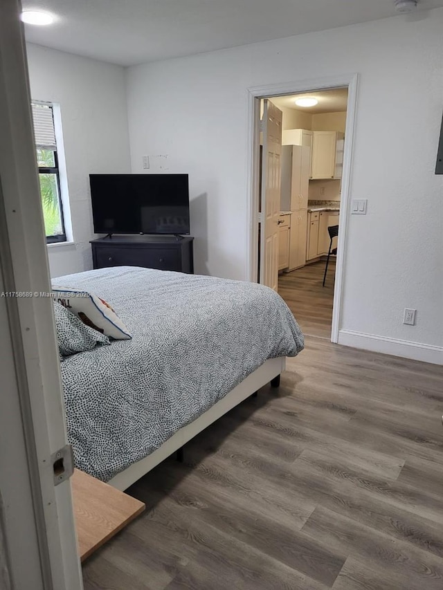 bedroom featuring baseboards and wood finished floors