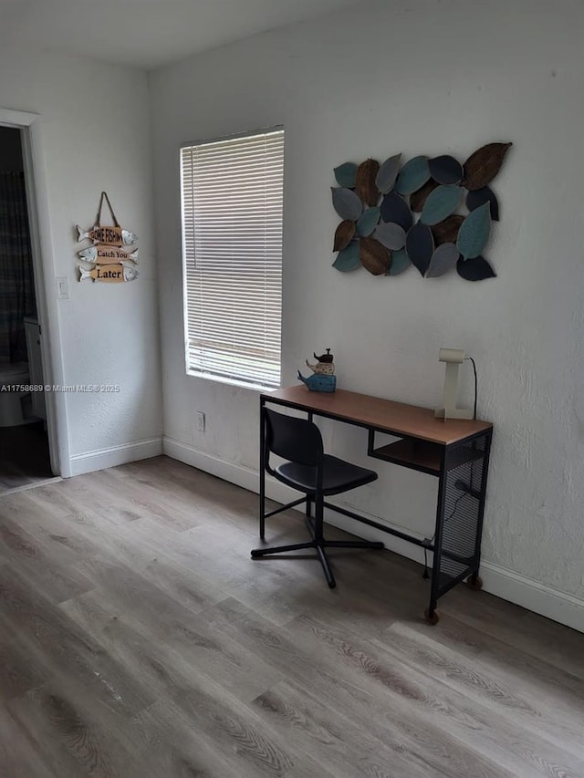 office space featuring baseboards and wood finished floors