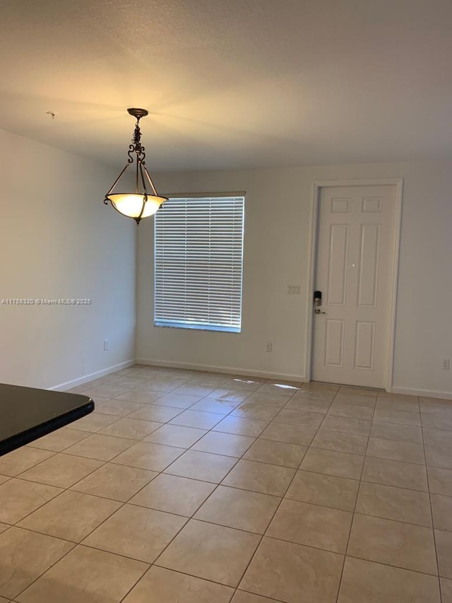 interior space featuring light tile patterned floors and baseboards