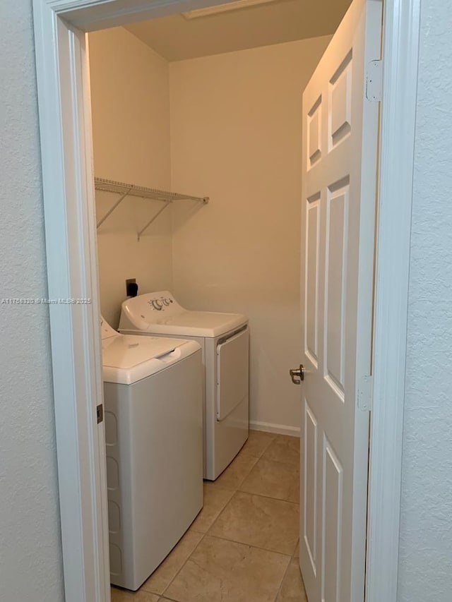 laundry area with laundry area, light tile patterned floors, and washer and dryer