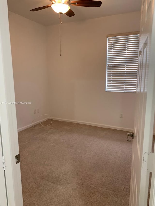 spare room featuring ceiling fan, carpet floors, and baseboards