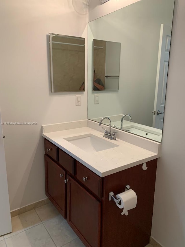 bathroom with baseboards, vanity, and tile patterned floors