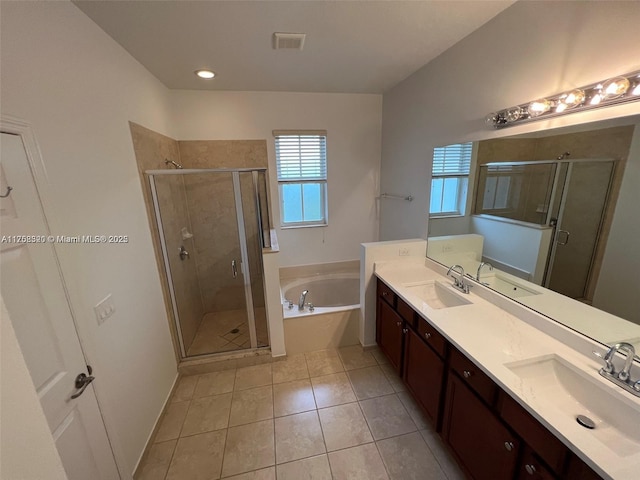 bathroom with a bath, a stall shower, a sink, and visible vents