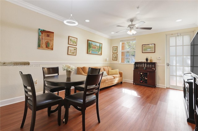 dining area featuring a ceiling fan, baseboards, ornamental molding, and wood finished floors