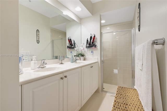 full bathroom featuring a stall shower, double vanity, and a sink