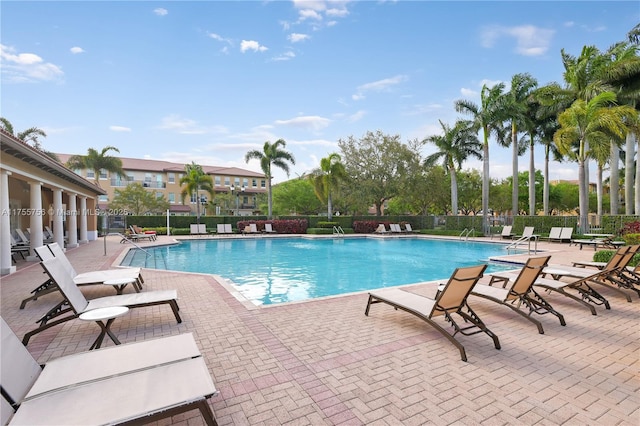 community pool with fence and a patio