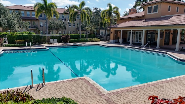 community pool with a patio and fence