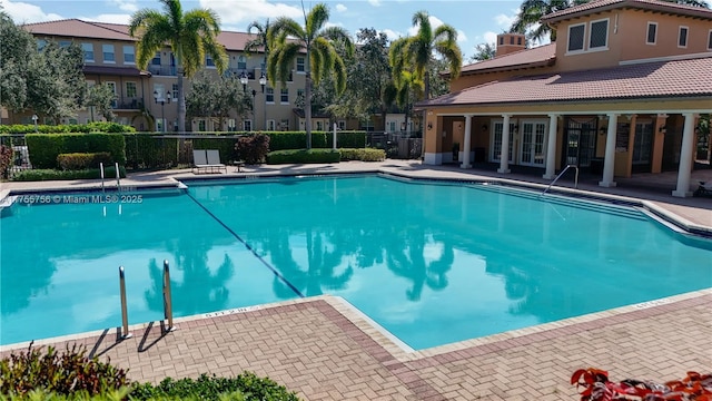 community pool with a patio area and fence