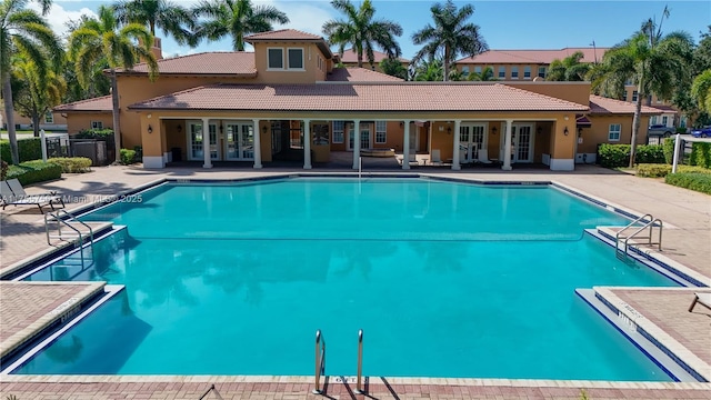 community pool with french doors, a patio area, and fence