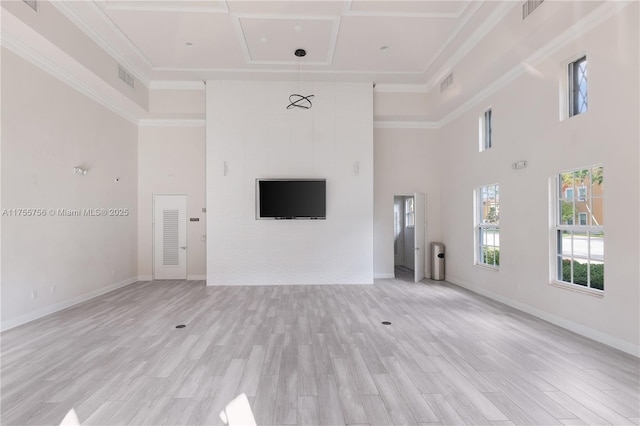 unfurnished living room with light wood-type flooring, a towering ceiling, and visible vents