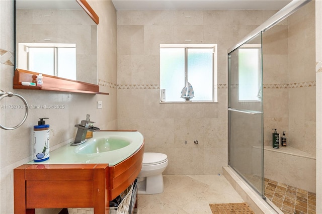 bathroom with toilet, a stall shower, tile walls, and vanity