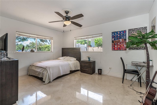 bedroom featuring multiple windows, ceiling fan, and baseboards