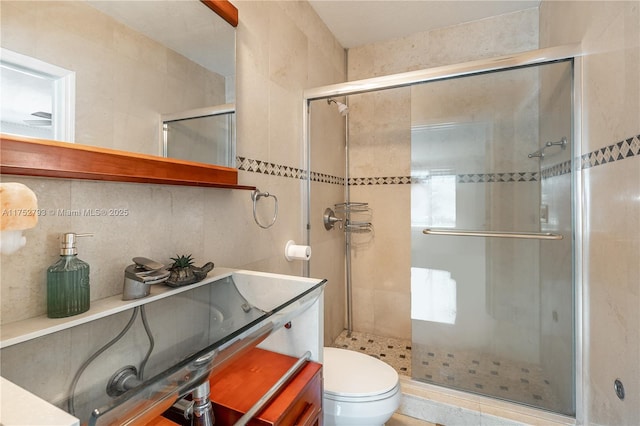 full bathroom featuring a stall shower, vanity, toilet, and decorative backsplash