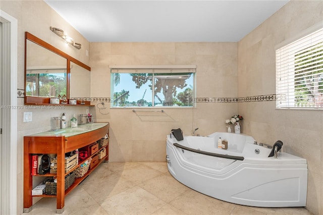 bathroom with a wealth of natural light, a jetted tub, tile walls, and vanity