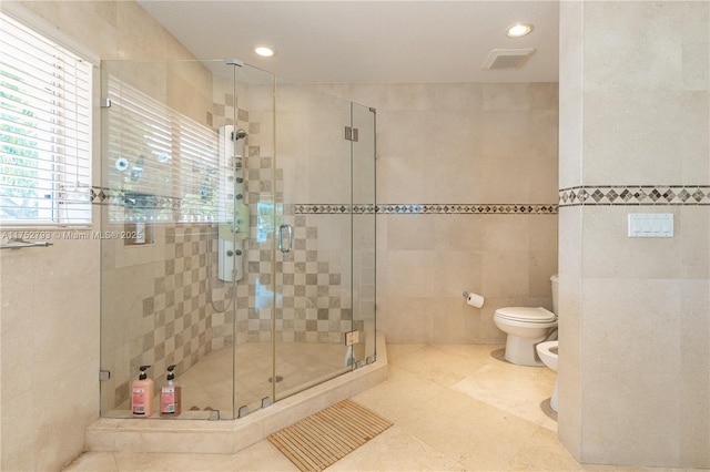 bathroom featuring visible vents, a shower stall, toilet, a bidet, and tile walls