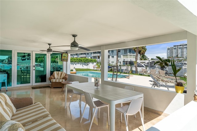 view of patio / terrace with french doors, outdoor dining area, a fenced in pool, and a ceiling fan