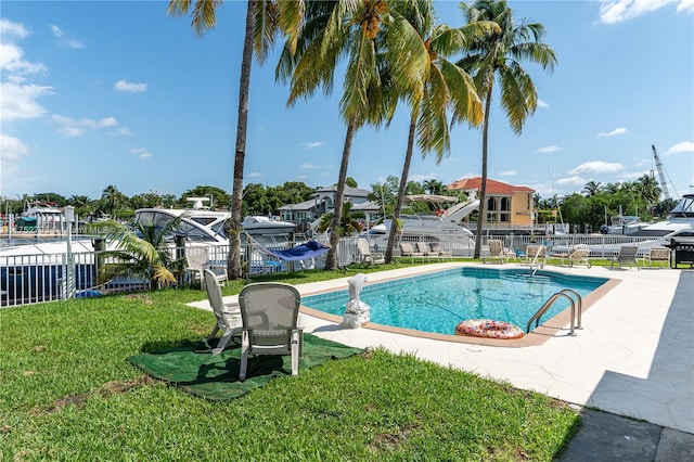 view of swimming pool featuring a yard, a fenced in pool, and fence