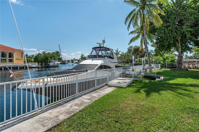 view of property's community with a dock, a yard, and a water view