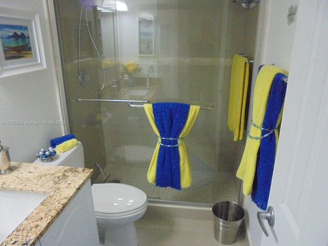 bathroom featuring toilet, a shower stall, and vanity