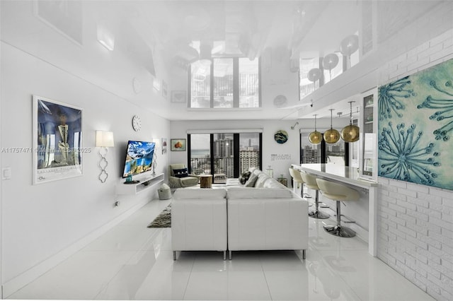 tiled living area with a towering ceiling