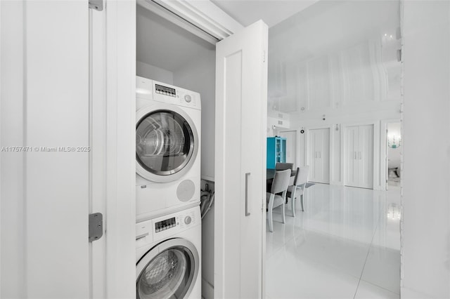 laundry area featuring stacked washer and dryer, laundry area, and tile patterned floors