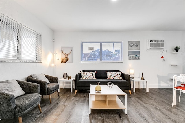 living room with a wall mounted AC, wood finished floors, and baseboards