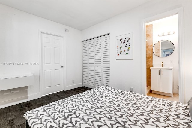 bedroom with a closet, wood finished floors, and baseboards