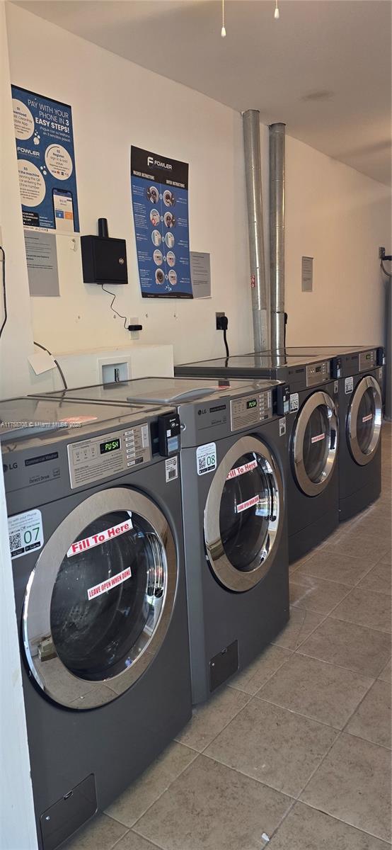 community laundry room with tile patterned flooring and independent washer and dryer