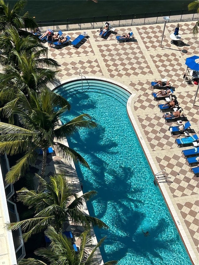 community pool with fence and a patio